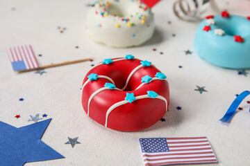 Composition with donuts, USA flags and confetti on white table, closeup. Independence Day celebration