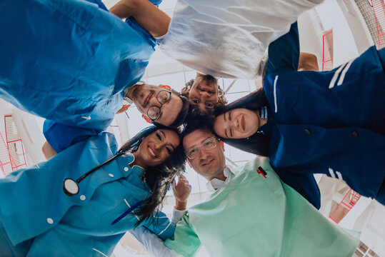  Group of doctors a medical nurse, and a surgeon are captured in a heartfelt embrace, showcasing their unity, teamwork, and profound connection in the healthcare field.