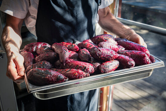 Chefs holding tray with grilled beetroot