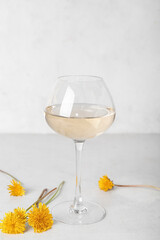 Glass of dandelion wine on white table