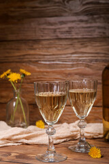 Glasses of dandelion wine on wooden table