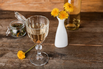 Glass of dandelion wine on wooden table