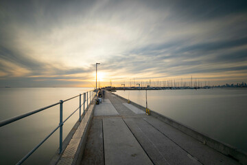 Fototapeta premium A jetty at sunset with a calm ocean