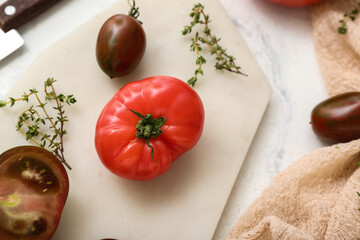 Board with fresh tomatoes on white background