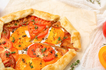 Baking paper with tasty tomato galette, closeup