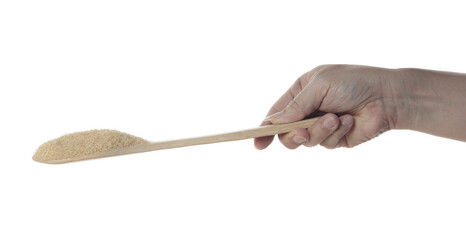 Brown Sugar fall, brown grain sugar pouring down abstract cloud fly from wooden spoon. Beautiful complete seed sugarcane, food object design. Selective focus freeze shot white background isolated