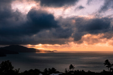 Fototapeta na wymiar A tropical landscape with the sun breaking through clouds onto the ocean
