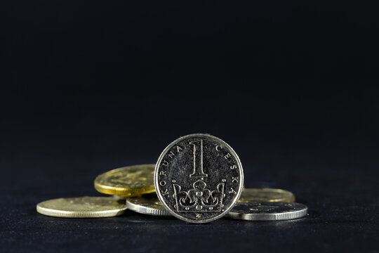 Selective blur on a one czech crown coin with the mention one crown written in czech, isolated on a black background. CZK, or Czech crown, or koruna, is the official currency and money of Czechia.