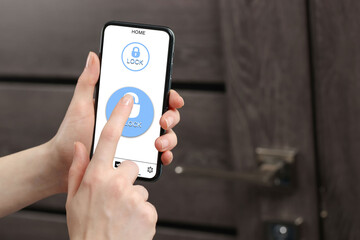 Woman unlocking door using mobile phone, closeup. Illustration of closed and open padlocks on device screen