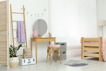 Fototapeta na wymiar Stylish teenager's room interior with wooden furniture and mirror