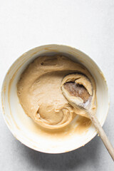 Churros dough in a white bowl, process of making churros, choux pastry dough about to be fried