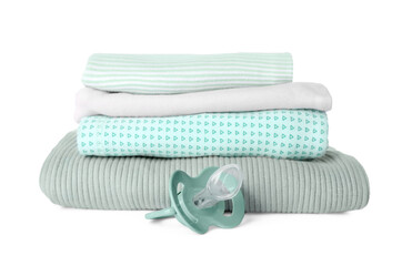 Stacked clothes and baby pacifier isolated on white