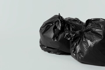 Trash bags full of garbage on light grey background. Space for text
