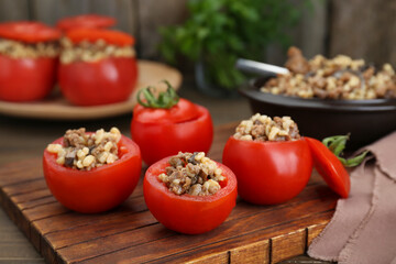 Delicious stuffed tomatoes with minced beef, bulgur and mushrooms on wooden board