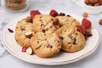 Cookies with freeze dried fruits and nuts on white marble table, closeup