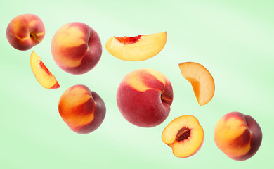 Cut and whole fresh ripe peaches falling on light green background