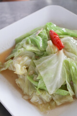 Stir-Fried Cabbage with Fish Sauce on White Square Plate on white background. Homemade Asian food.
