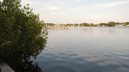 Wide angle view Coffee Pot Bay in Saint Petersburg, FL.  Wood Pier in the background. Sunny day with blue sky and calm water. With green trees.