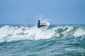 Young athletic surfer rides the wave