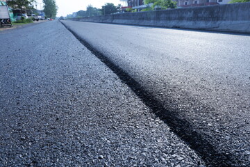 Shallow depth of asphalt on the road. Closeup of different asphalt road surface in side view in the middle of the road while undertaking construction or renovation with copy space with selective focus