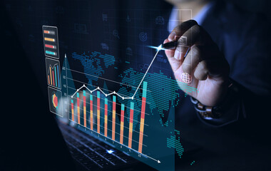 Businessman is analyzing investment trend chart or profit and loss income through computer screen...