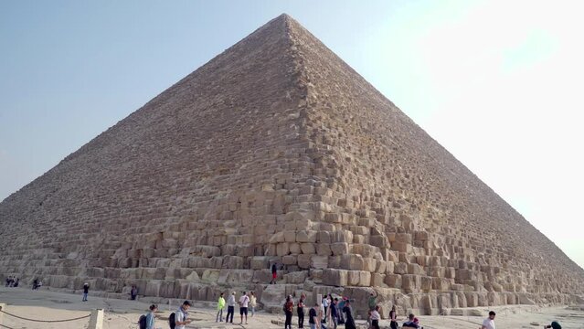Giza, Egypt. December 2022. Panoramic view of the Great Pyramid of Giza. Some tourists admire the place and take photos. They are considered one of the seven wonders of the world.