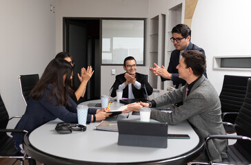 business team clapping celebrating for signing a new partnership contract at a meeting room coworking space of hispanic teamwork at the office