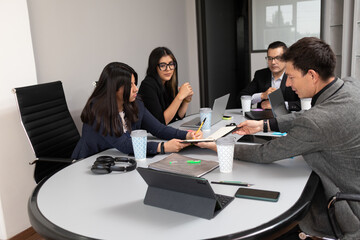 business people signing document contract in a meeting room office, mixed race hispanic businesswoman writing terms and conditions of work