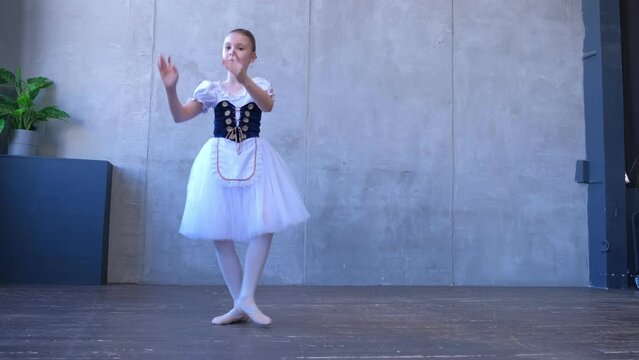 A teen girl dancer in a ballet school is learning to dance. Little ballerina in training in a dance costume. Children's ballet school. 4K