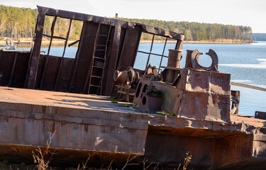 The rusty remains of a ship on the riverbank