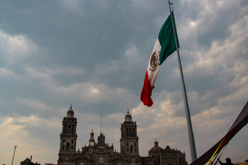 Vista de la bandera de México en la plaza junto a la Catedral Central en Ciudad de México en un cielo nublado