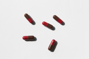red and brown color pills on a white background