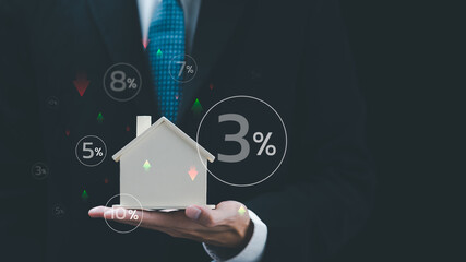 Real estate agent holding model house showing fluctuating interest rate concept ,Financial interest...
