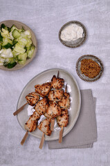 Fried slices of meat on wooden skewers.