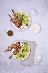 Fried slices of meat on wooden skewers.