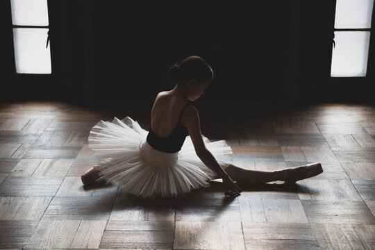 teenage ballet dancer stretching on the floor