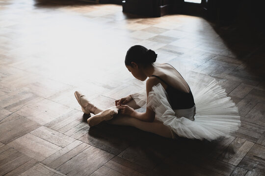 Fototapeta teenage ballerina tying pointe shoes