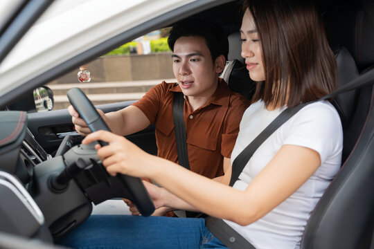 Image of young Asian couple with car
