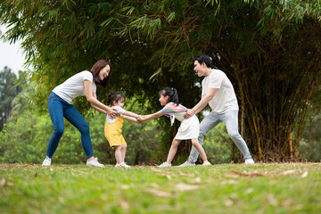 Naklejka na ściany i meble Young Asian family in the park