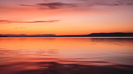 Fototapeta premium An orange and pink sunset over a lake with mountains in the distance Generative Ai