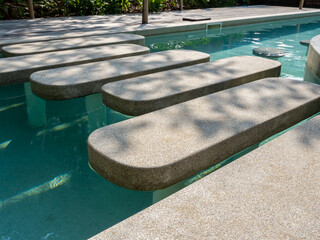 Empty terrazzo pathway steps with leaves shade lying, across the clean and clear water swimming...