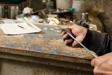 Fototapeta na wymiar Shaping the Vision: Talented Blacksmith Sanding Metal Rod for Masterpiece