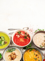 Composition with various soups, ingredients and space for text on white background. Healthy food.