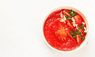 Tomato soup on white table, top view