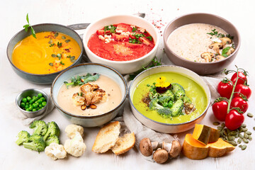 Composition with various soups, ingredients and space for text on white background. Healthy food.