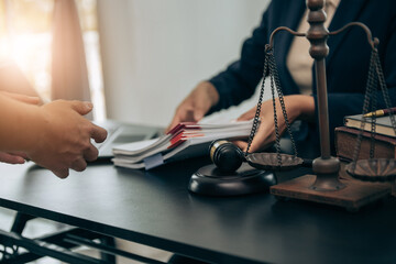 Beautiful young woman lawyer sitting in front of laptop in room with documents and smartphone with empty hammer and scale next to it justice and legal concept