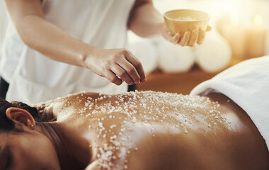 Woman, hands and salt in massage at spa for skincare, exfoliation or body treatment at resort. Hand...