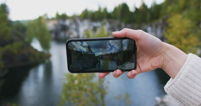 Taking a photo of a scenic nature view with a phone, fpv of taking a picture with a smartphone 
