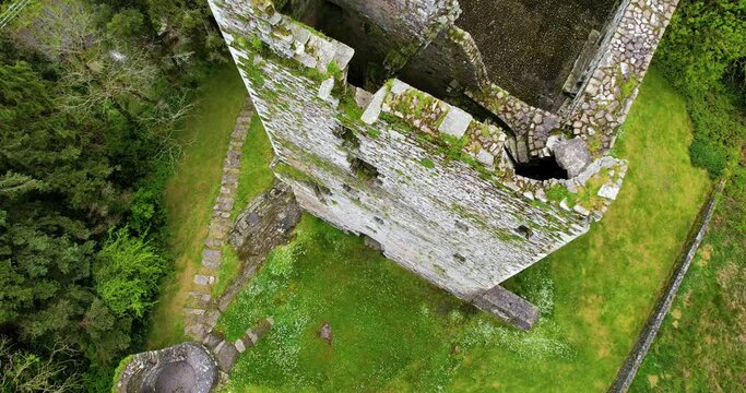 A fly over Drone 4K Reveal of Ballinacarriga Castle  a 16th-century tower house located in the village of Ballinacarriga Co Cork Ireland