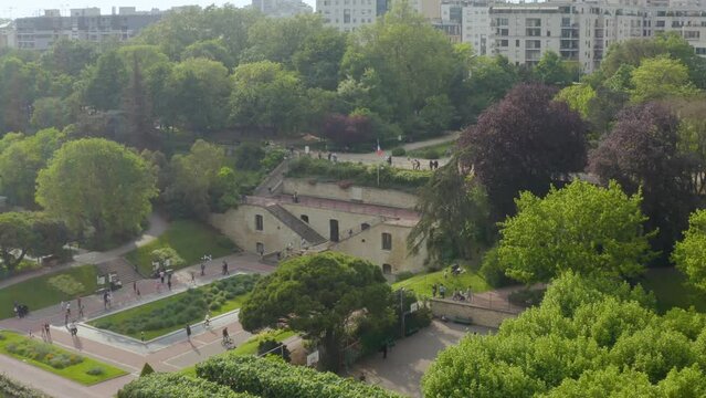 Aerial shot of children and families playing in the B&eacute;con park surrounded by trees, in Paris, France
